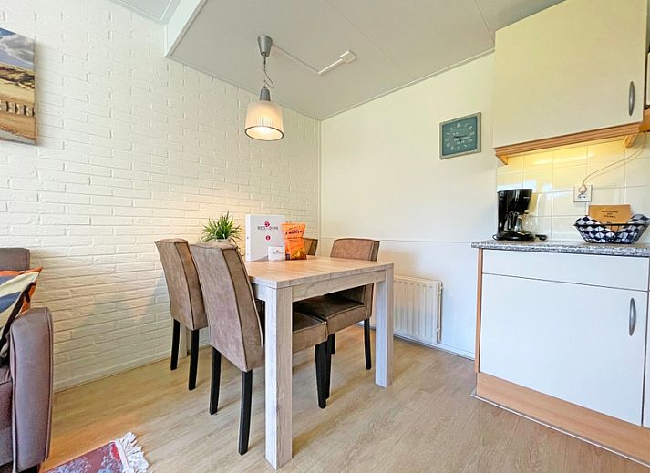 Gemuetliches Wohnzimmer des Appartements Bos en Duin 31 in De Dennen, Texel mit bequemer Sitzecke und Blick auf die Natur.