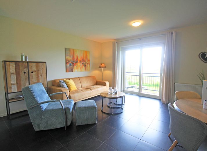 Gezellige woonkamer in Appartement Bos en Duin 42, De Dennen, Texel met comfortabele bank en warme verlichting.