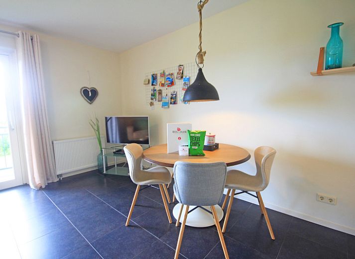 Gezellige woonkamer in Appartement Bos en Duin 42, De Dennen, Texel met comfortabele bank en warme verlichting.