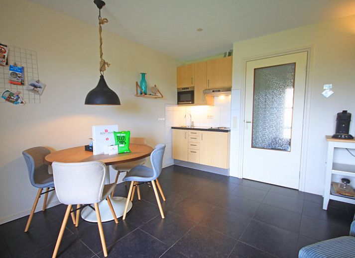 Gezellige woonkamer in Appartement Bos en Duin 42, De Dennen, Texel met comfortabele bank en warme verlichting.