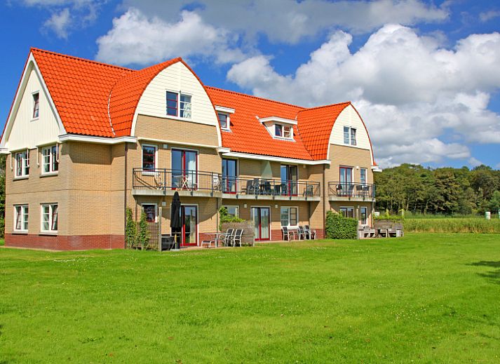 Lichte woonkamer van Appartement Bos en Duin 42, De Dennen, Texel met uitzicht op het groene landschap.