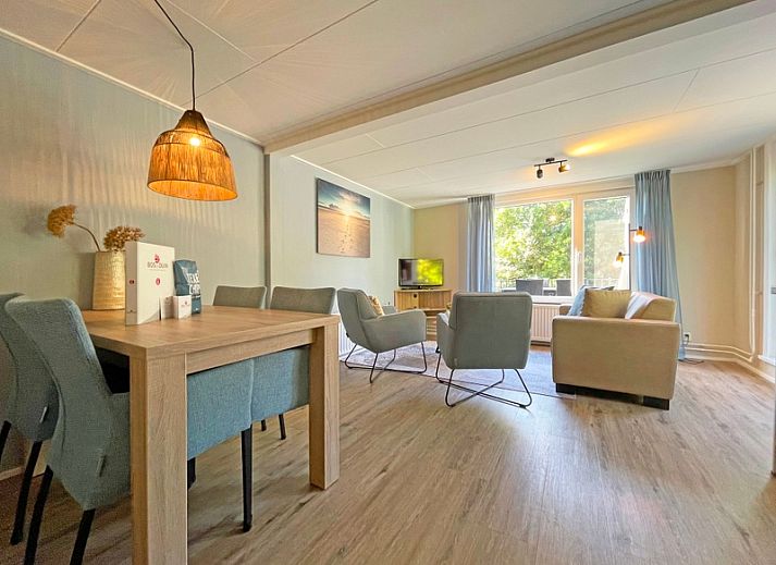 Cozy living room in Apartment Bos en Duin 22, De Dennen, Texel with comfortable furniture and large windows.
