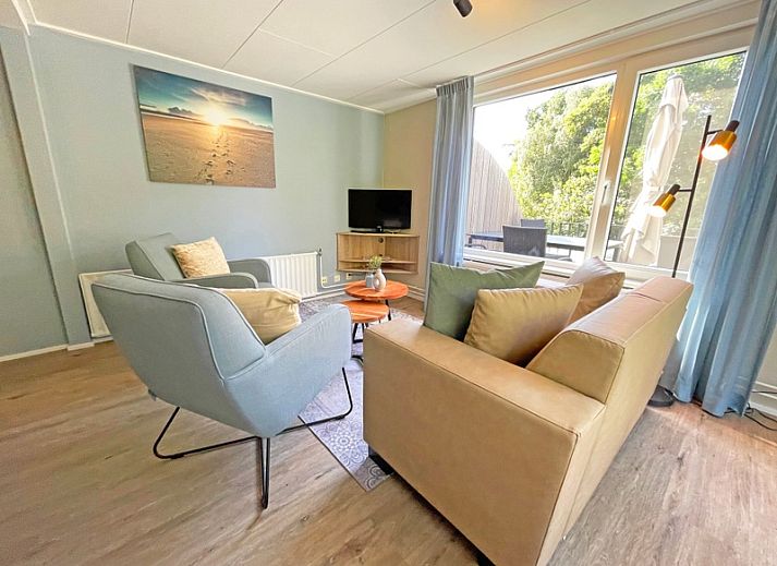 Cozy living room in Apartment Bos en Duin 22, De Dennen, Texel with comfortable furniture and large windows.
