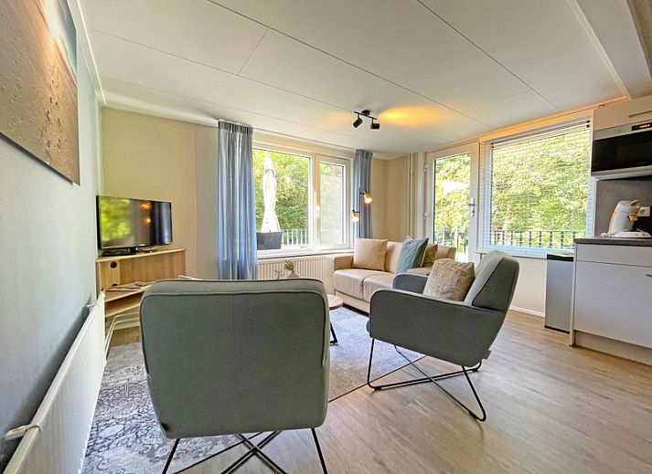 Cozy living room in Apartment Bos en Duin 22, De Dennen, Texel with comfortable furniture and large windows.