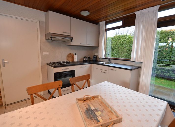 Cozy living room in Holiday home de Parel 258, Texel, overlooking the garden.