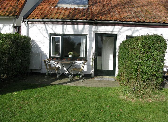 Veranda des Ferienhauses Duumpie in De Dennen, Texel mit Sitzgelegenheiten und gruener Umgebung.
