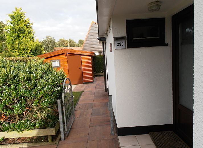 Terrasse im Ferienhaus Gortersmient 298 in De Dennen, Texel mit Gartenmoebeln und gruener Umgebung.