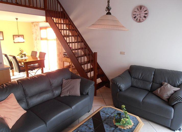 Terrasse im Ferienhaus Gortersmient 298 in De Dennen, Texel mit Gartenmoebeln und gruener Umgebung.