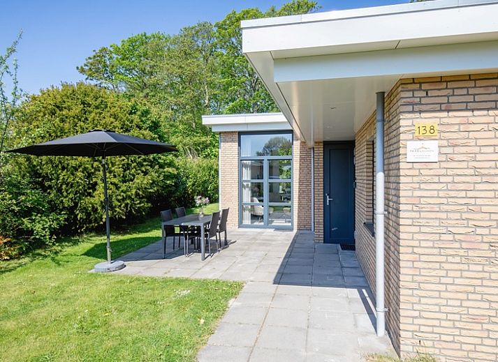 Bungalowpark Verste Coogh - Hermelijn in De Dennen, Texel mit sonniger Terrasse und gruener Umgebung.