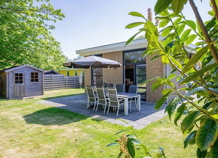 Bungalowpark Verste Coogh - Hermelijn in De Dennen, Texel mit sonniger Terrasse und gruener Umgebung.
