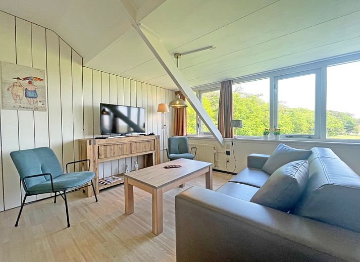 Geraeumiges Wohnzimmer im Apartment Bos en Duin 35, De Dennen, Texel mit moderner Einrichtung und Blick auf die Natur.