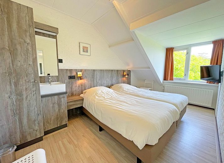 Gemuetliche Sitzecke im Apartment Bos en Duin 35, De Dennen, Texel mit bequemen Sofas und grossen Fenstern.