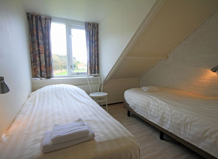 Gemuetliche Sitzecke im Apartment Bos en Duin 35, De Dennen, Texel mit bequemen Sofas und grossen Fenstern.