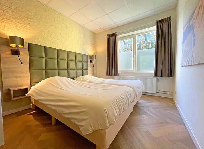 Bright and spacious dining room in Apartment Bos en Duin 04, De Dennen, Texel with wooden table and modern chairs.