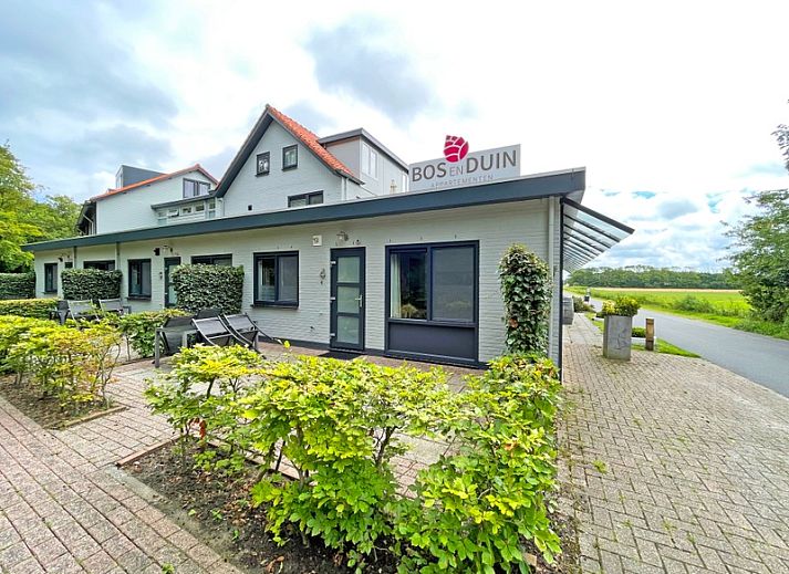Bright and spacious dining room in Apartment Bos en Duin 04, De Dennen, Texel with wooden table and modern chairs.