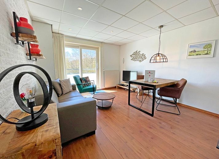 Gemuetliches Wohnzimmer im Apartment Bos en Duin 18, De Dennen, Texel mit bequemem Sofa und Blick auf die Natur.