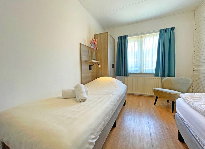 Stilvolle Sitzecke im Apartment Bos en Duin 11, De Dennen Texel mit bequemen Sofas und Gartenblick.