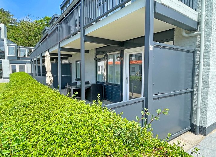 Stilvolle Sitzecke im Apartment Bos en Duin 11, De Dennen Texel mit bequemen Sofas und Gartenblick.