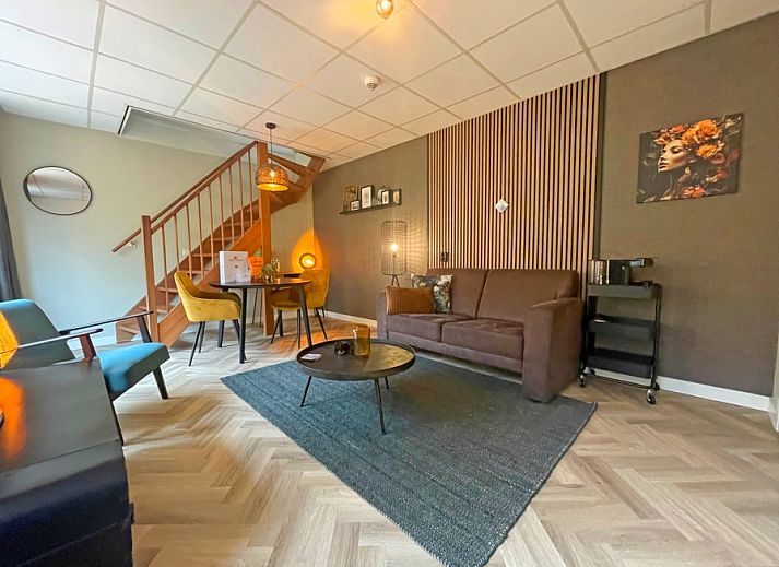 Gemuetliches Wohnzimmer im Appartement Bos en Duin 24, De Dennen, Texel mit bequemem Sofa und stimmungsvoller Beleuchtung.