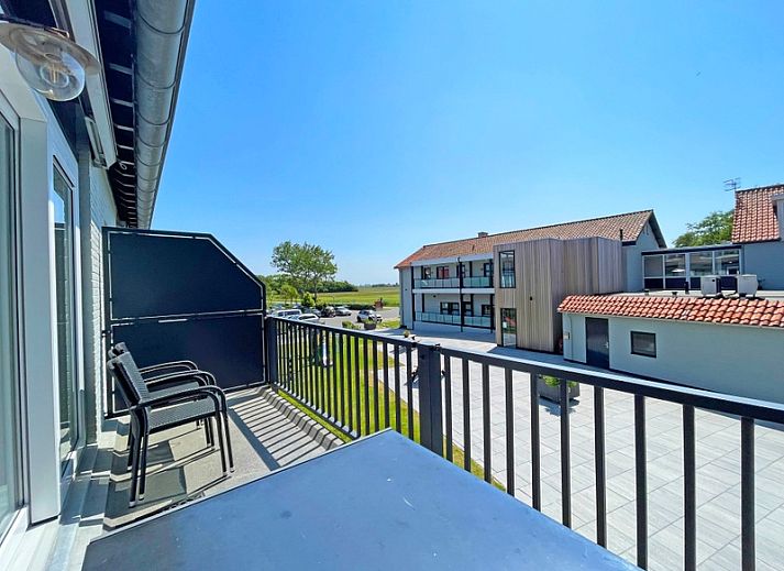 Stylishly furnished sitting area in Apartment Bos en Duin 27, De Dennen, Texel with comfortable sofa and decorative elements.