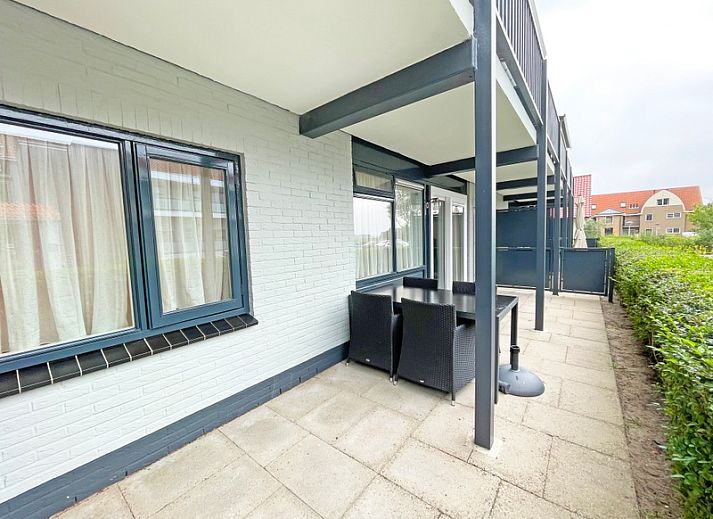 Ruime woonkamer van Appartement Bos en Duin 10, De Dennen, Texel met comfortabele bank en flatscreen-tv.