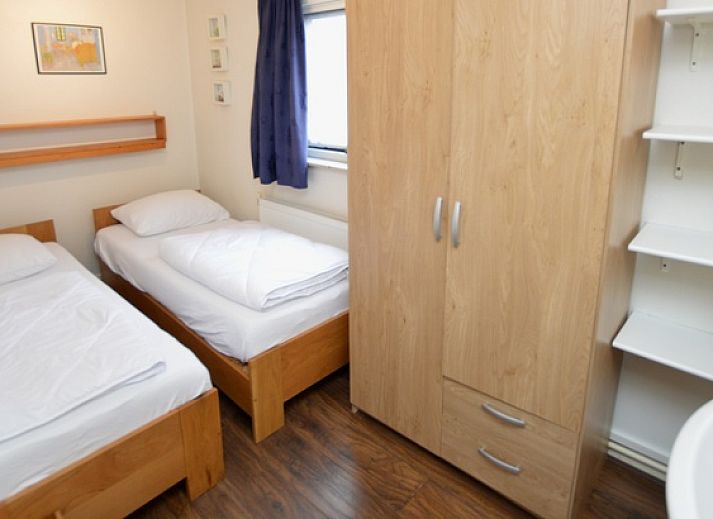 Gezellige woonkamer van Vakantiehuis de Parel 160 in De Dennen, Texel, met uitzicht op de groene omgeving en een knusse open haard.