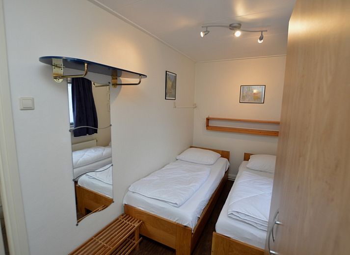 Gezellige woonkamer van Vakantiehuis de Parel 160 in De Dennen, Texel, met uitzicht op de groene omgeving en een knusse open haard.