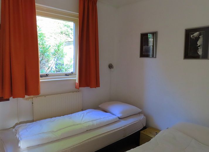 Ruhige Terrasse des Ferienhauses Dunkonijn, De Dennen, Texel, umgeben von gruener Natur.