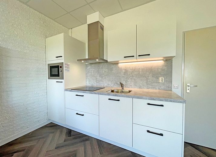 Cozy sitting area in Apartment Bos en Duin 02, De Dennen, Texel with comfortable sofas and cozy decorations.