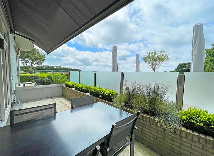 Cozy sitting area in Apartment Bos en Duin 02, De Dennen, Texel with comfortable sofas and cozy decorations.