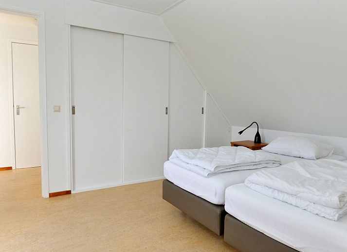 Roodborstje Ferienhaus mit Terrasse in De Dennen, Texel, umgeben von Baeumen.