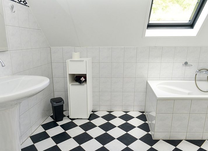 Roodborstje Ferienhaus mit Terrasse in De Dennen, Texel, umgeben von Baeumen.