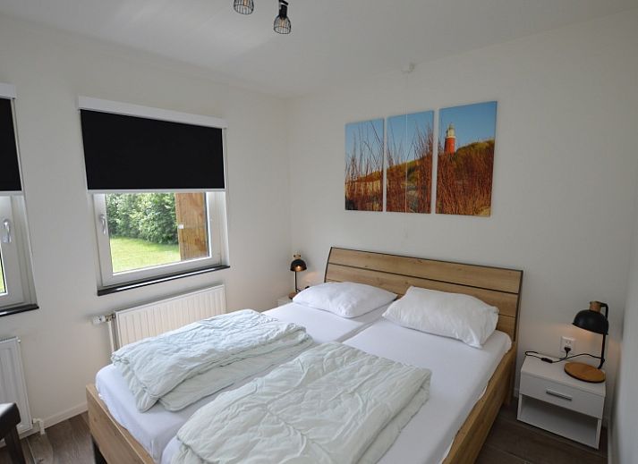 Gezellige woonkamer in Tempelierweg 17 vakantiehuis, De Dennen, Texel, met uitzicht op de tuin.