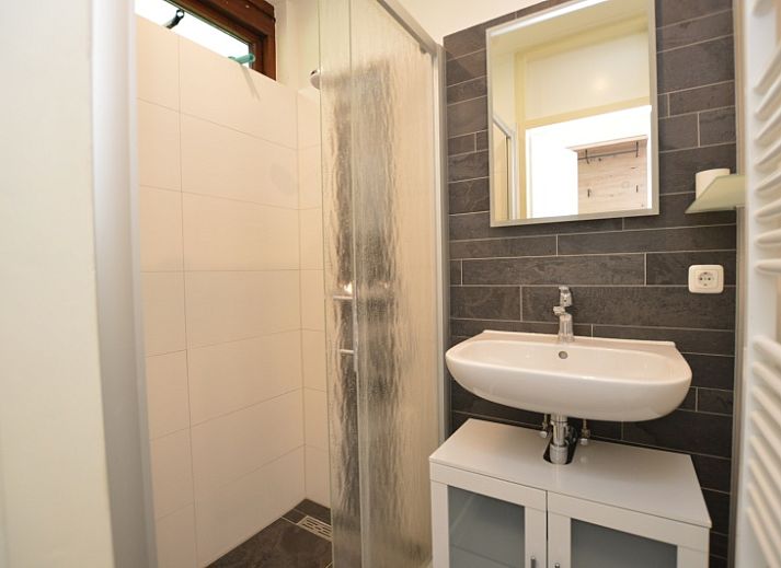 Gezellige woonkamer in Tempelierweg 17 vakantiehuis, De Dennen, Texel, met uitzicht op de tuin.