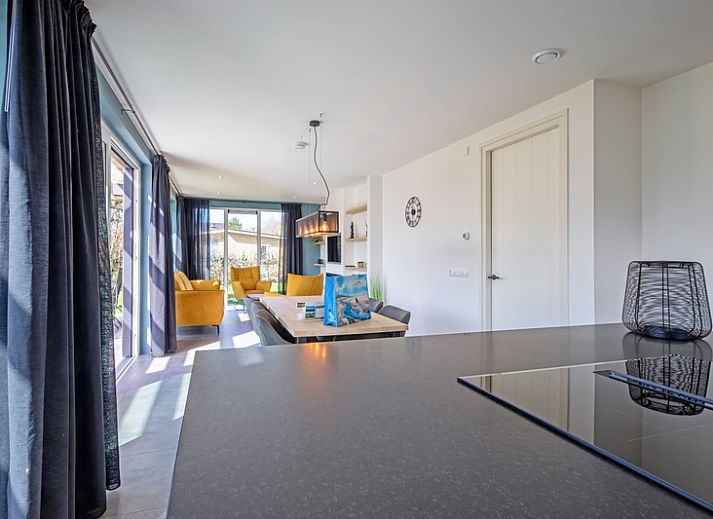 Ontspannen op het terras van Bungalowpark 't Luwe Land - Nieuw Vredelust, Texel. Comfortabele ligstoelen en natuurlijke omgeving.