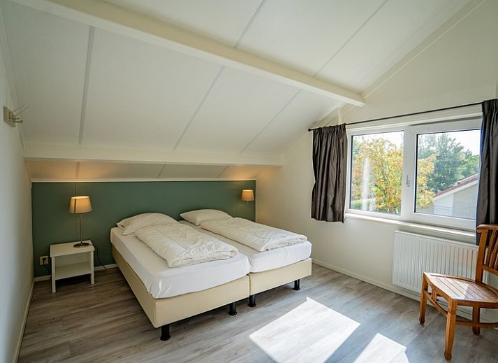 Offener Wohnbereich im Ferienhaus 't Hoogelandt 134A De Dennen Texel mit Blick auf den gruenen Garten.