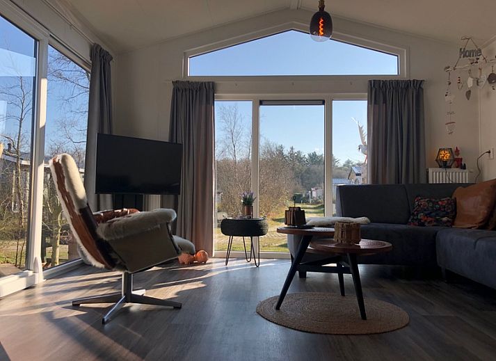 Gemuetliches Wohnzimmer im Ferienpark de Bremakker - Bosveld 121, De Dennen, Texel mit komfortabler Einrichtung und Blick auf die Natur.