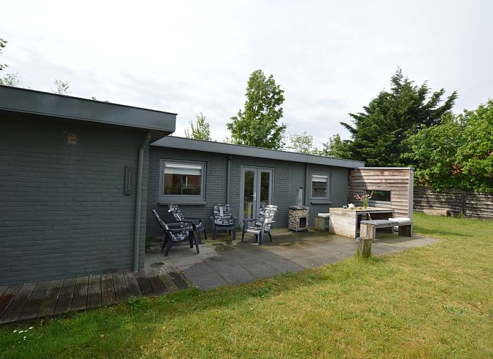 Gemuetliche Veranda im Bungalow 't Hoogelandt 24 in De Dennen, Texel, mit bequemen Stuehlen und gruener Umgebung.
