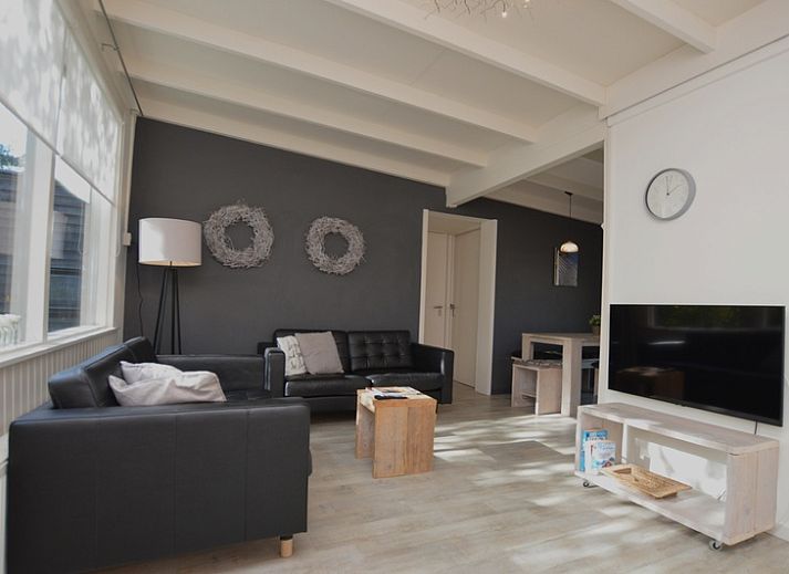 Gemuetliche Veranda im Bungalow 't Hoogelandt 24 in De Dennen, Texel, mit bequemen Stuehlen und gruener Umgebung.