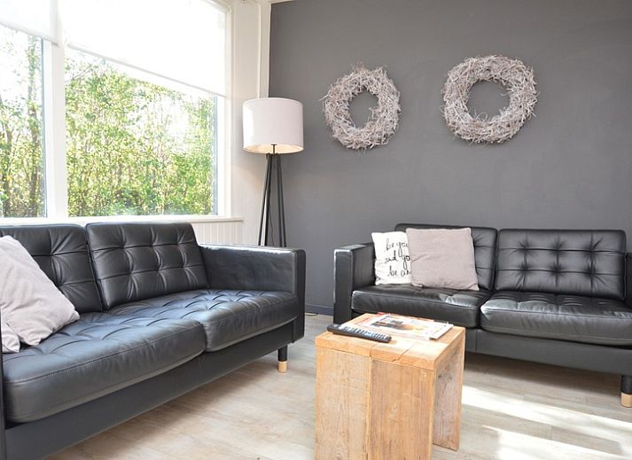 Gemuetliche Veranda im Bungalow 't Hoogelandt 24 in De Dennen, Texel, mit bequemen Stuehlen und gruener Umgebung.