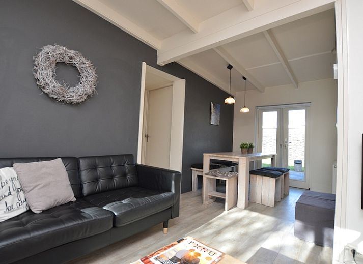 Gemuetliche Veranda im Bungalow 't Hoogelandt 24 in De Dennen, Texel, mit bequemen Stuehlen und gruener Umgebung.