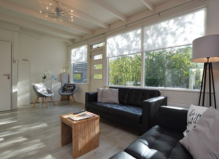 Stilvolles Wohnzimmer von Bungalow 't Hoogelandt 24, De Dennen, Texel mit modernen grauen Sofas und viel Tageslicht.