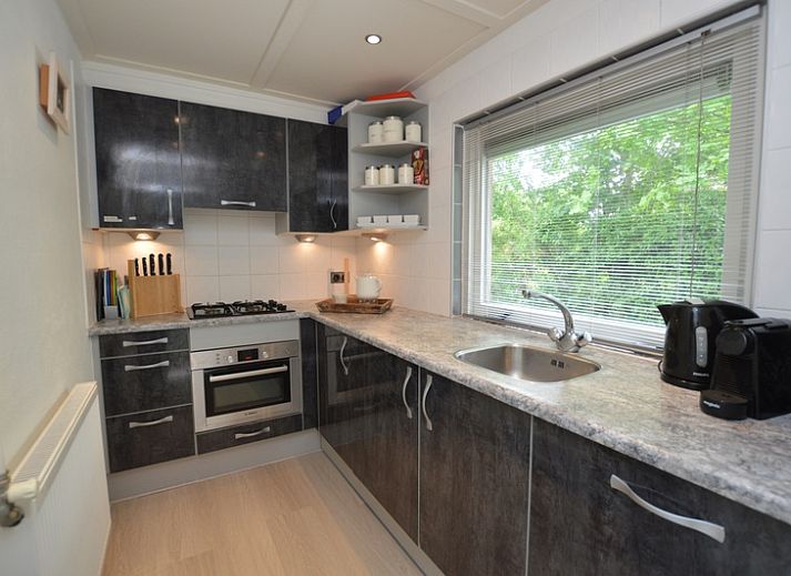 Stilvolles Wohnzimmer von Bungalow 't Hoogelandt 24, De Dennen, Texel mit modernen grauen Sofas und viel Tageslicht.