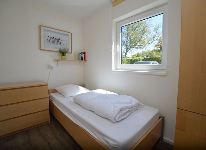 Gemuetliches Wohnzimmer des Ferienhauses de Parel 262 in De Dennen, Texel mit Blick auf den Garten.