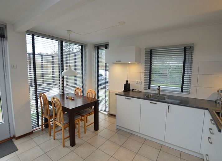 Gemuetliches Wohnzimmer im Ferienhaus de Parel 244, De Dennen, Texel mit Blick auf den Garten, ideal fuer Entspannung auf den Watteninseln.