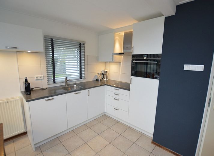 Gemuetliches Wohnzimmer im Ferienhaus de Parel 244, De Dennen, Texel mit Blick auf den Garten, ideal fuer Entspannung auf den Watteninseln.