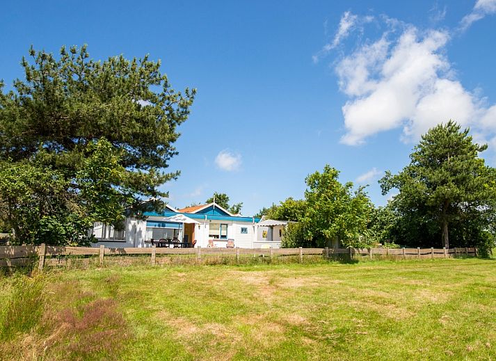 Meadow View vacation home in De Dennen, Texel with surrounding nature and blue sky.