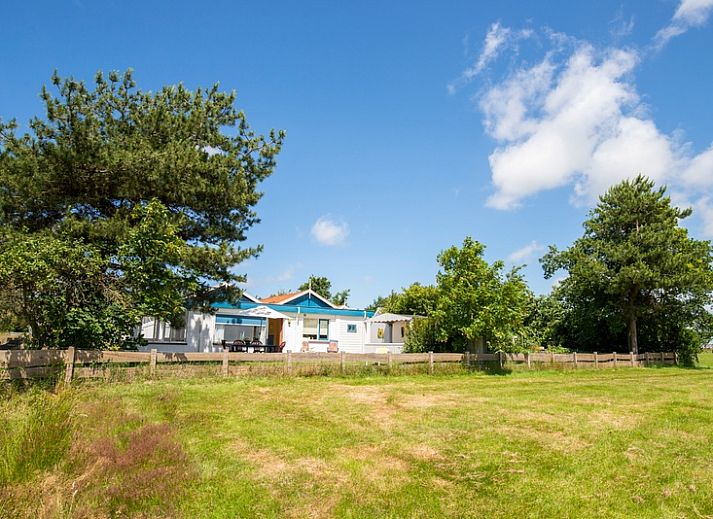 Meadow View vacation home in De Dennen, Texel with surrounding nature and blue sky.