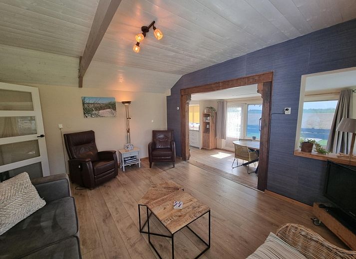 View of Weidezicht in De Dennen, Texel, surrounded by greenery and clear blue sky.