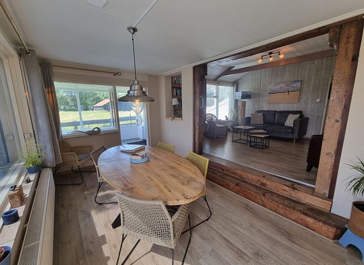 View of Weidezicht in De Dennen, Texel, surrounded by greenery and clear blue sky.